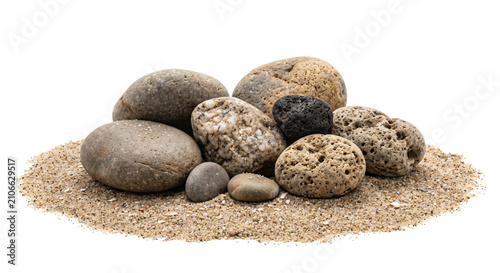 Foto Assortment of smooth and porous stones resting on fine beach sand