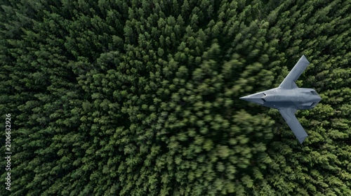 A sleek military combat aircraft performs a low altitude patrol sortie soaring swiftly above the dense canopy of a vast coniferous evergreen woodland forest area during the bright daylight hours