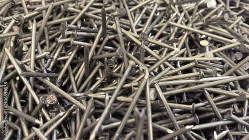 A close look at a box filled with countless nails showcasing their varied shapes and sizes. Each nail tells a story of craftsmanship and potential projects waiting to unfold.