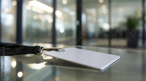Blank ID badge lanyard glass table office corporate security access card close up near blurred workplace background with modern professional identity concept