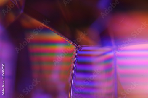 Cinematic purple fluid lattice macro with rainbow spectral interference. Atmospheric horizontal macro photo of a structured liquid surface.