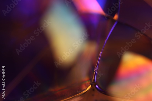 Vibrant multicolor fluid film vertex with geometric bubble boundaries. Complex geometric film boundaries intersect at a central fluid node in a low-key macro perspective.