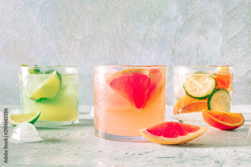 Refreshing summer cocktails with ice cubes on a light background