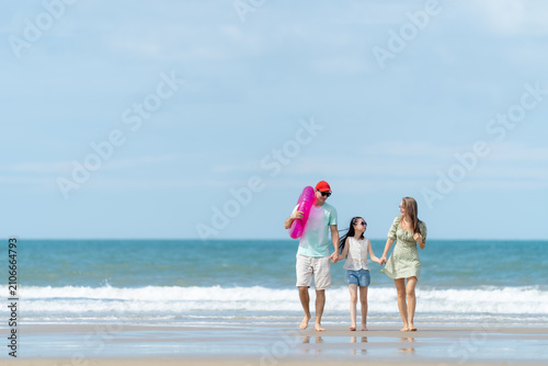 Фотография A cheerful family enjoys a peaceful beach vacation surrounded by blue skies and ocean waves representing love relaxation and meaningful family moments