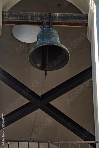 фотографія Large bronze bell hanging in a church tower with wooden beams and stone belfry i