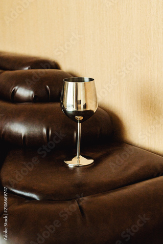 a silver glass on the brown couch in the room interior 