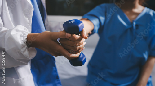 Physical therapist giving stretching exercises with elastic exercise bands and physical therapist hands helping male patient Physical therapy concept