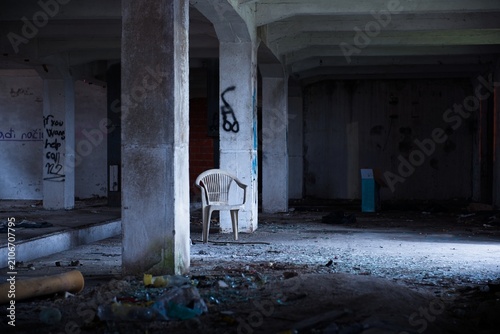 Bild auf Leinwand Broken plastic chair in abandoned messy warehouse