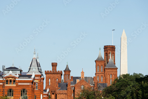 Obraz na płótnie Smithsonian Castle and museums on the National Mall with green lawn and Washington Monument in background, DC, USA
