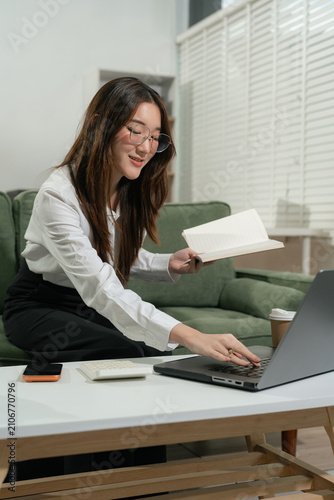 accountant working on desk in office using calculator and laptop to calculate budget. concept finance and accounting in morning light.