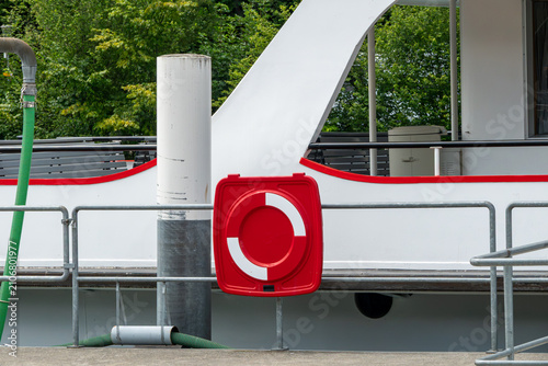 Photos Emergency lifebuoy station at a riverside dock with passenger boat in background