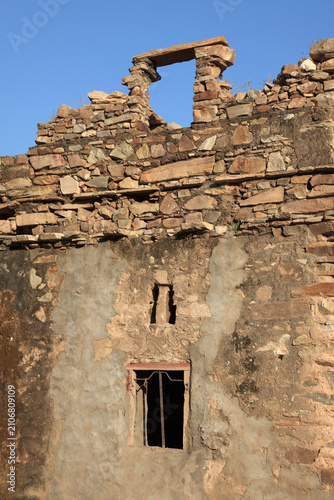 Weathered stone wall ruins under a clear blue sky