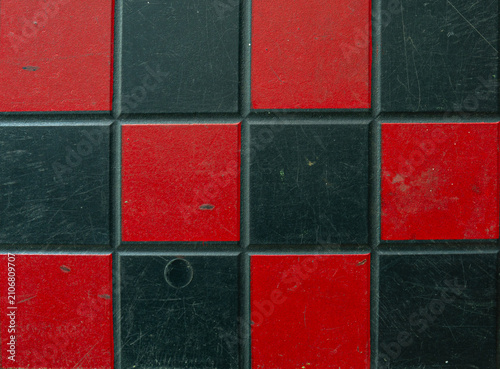 Worn red and black checkered tile texture background