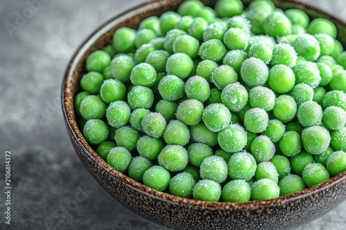 Close-up of frosty bright green peas piled in a ceramic bowl, conveying fresh, cold and appetizing crispness