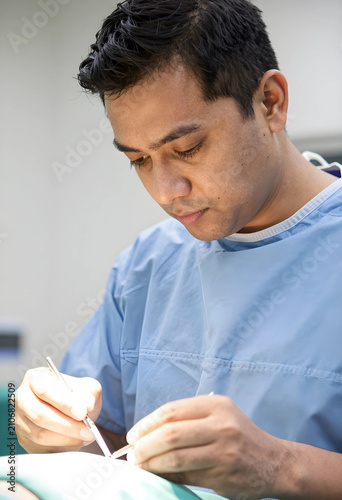 Male surgeon in blue scrubs...