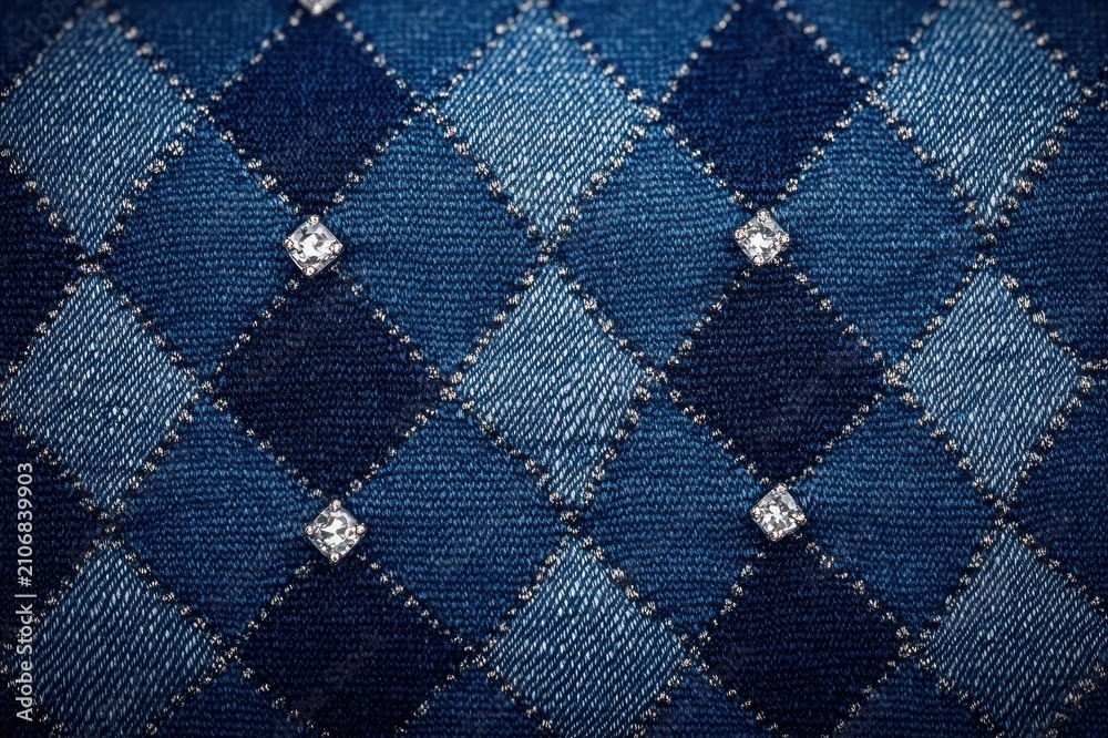 Fototapeta premium close-up of blue argyle denim fabric with stitched diamond pattern and small sparkling rhinestones, stylish cozy textile texture