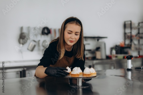 Pastry chef arranging meringue tartlets in a commercial kitchen