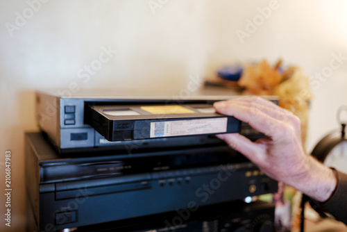 Foto Inserting vhs cassette into vcr player for retro entertainment