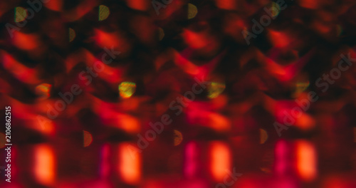 Patterned effect. Blur lens gleam. Defocused red pink color flare flicker sparkle glimmer shine on abstract bokeh light art dark black background.