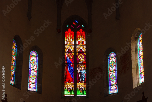 France. Lot. Saint-Cirq-Lapopie. Interior of the Church of Saint-Cyr-et-Sainte-Julitte, featuring a central stained-glass window depicting Christ as 