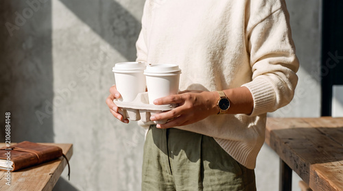 Person Holding Two Takeaway Coffee Cups in Cardboard Drink Carrier