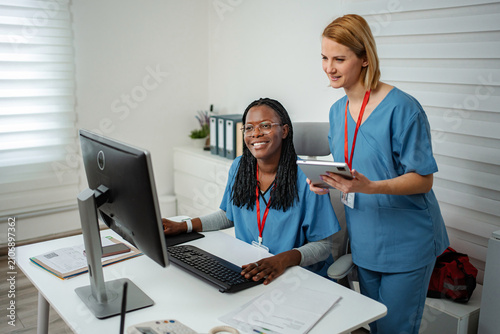 Obraz na plátně Diverse medical workers collaborating on computer and digital tablet