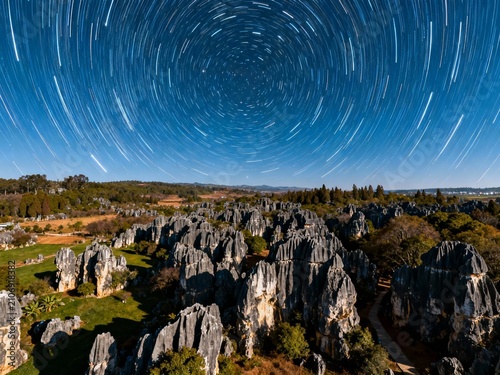 Star trail over a rocky limestone landscape at night