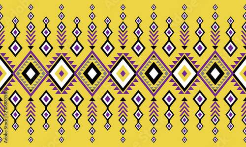 Seamless yellow, purple, black and white tribal geometric pattern featuring Native American inspired diamonds, arrows, ornamental motifs and ethnic textile design.