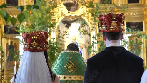 Bride and groom wearing crowns during traditional Orthodox wedding ceremony
