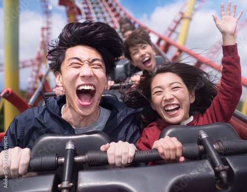 ジェットコースターで絶叫する若い男女