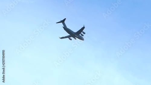 Military Cargo Aircraft Flying Across Clear Blue Sky During Daylight Showcasing Strategic Airlift Operations and Aviation Excellence