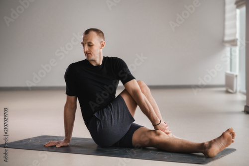 Konstfotografi An athletically built man does yoga in the gym on a mat