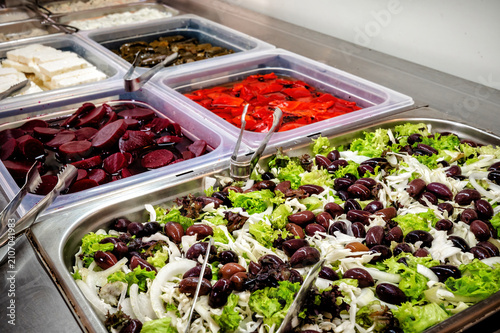 Colorful self-service buffet with fresh vegetables, olives and traditional Mediterranean ingredients prepared for hotel guests in a modern restaurant.