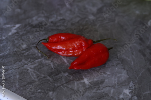 Cuadro en lienzo Fresh red Peruvian aji limo chili peppers on a dark stone surface