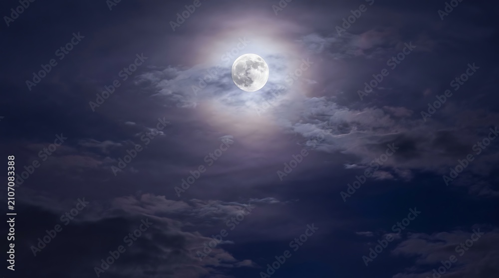 Fototapeta premium Full moon glows brightly amidst dramatic clouds at night. A celestial and atmospheric element for cosmic or mystical.