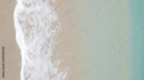 vertical natural landscape sea beach sea water surface while sea waves is crashing on golden white sand beach splashing white bubble.seascape summer holiday background,summer beach south of thailand