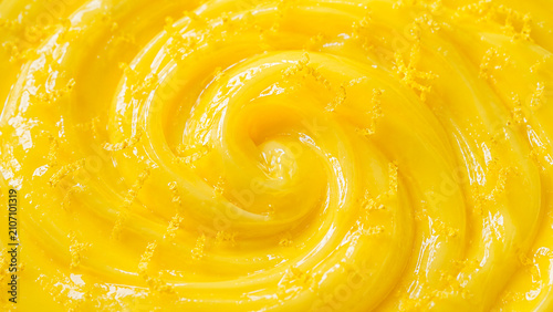 A glossy yellow cream texture creates a vibrant abstract food background.