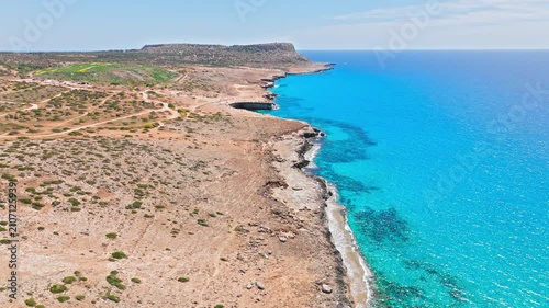 Drone view of Cape Cavo Greco coastline in Cyprus. Deep blue water, rugged cliffs and open coastal scenery stretch along the Mediterranean shore.