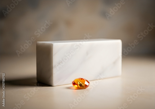 Imperial topaz gemstone displayed with polished marble block luxury jewelry presentation studio lighting