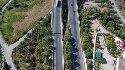 Aerial top-down view of highway lanes tilting up to mountain tunnel