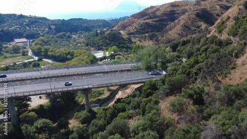 Aerial wide angle view of highway overpass over plain toward tunnel
