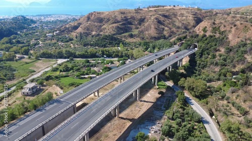 Aerial wide angle view of highway bridge over plain entering tunnel