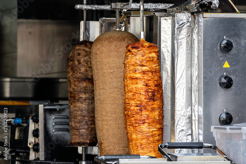 фотографія vertical rotisserie spits loaded with layers of seasoned meat for döner kebab