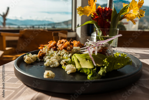 Fotografía Gourmet presentation of traditional mote with crispy pork chicharron, avocado, a