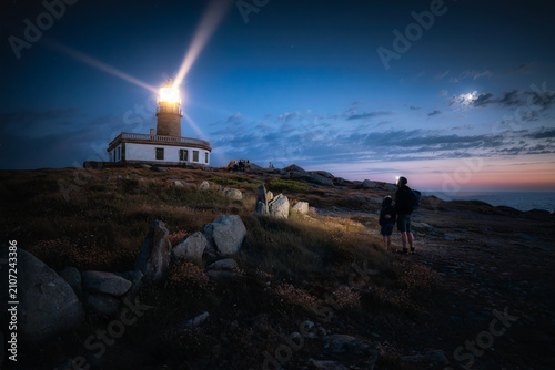 A father and son watch the flash of a lighthouse after dark. When the night grows dark, we all wish we had a guide to help us find our way.