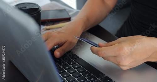 Focused work scene. Person verifying bill with laptop. Individual handling documents and digital payment processing. Someone reviewing bills and utilizing computer with coffee close by