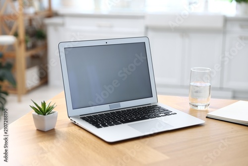 Comfortable workplace with laptop on wooden table indoors, closeup
