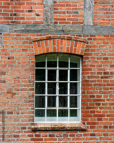 Old wooden window on red brick wall facade