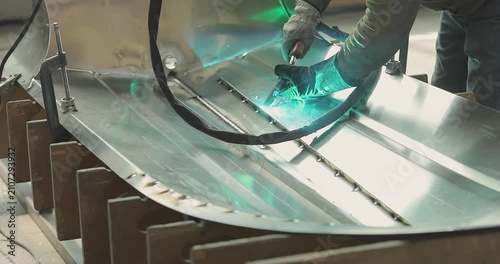 Production of an aluminum hull for a RIB boat. Welder weld a aluminum boat hull. Production of an aluminum hull for a motorboat. Close-up. Welding process in the shop.