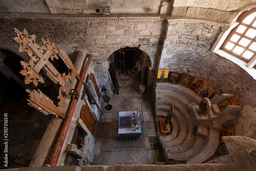 Elevated view inside the northern chapel of Panagia Ekatontapiliani in Parikia, Paros, Greece, showing Byzantine stonework, altar, icons and a carved wooden cross.